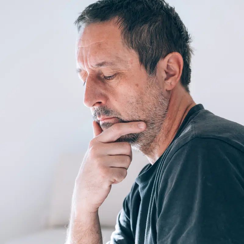 A man has his hand on his chin a nd looks like he is reading something serious