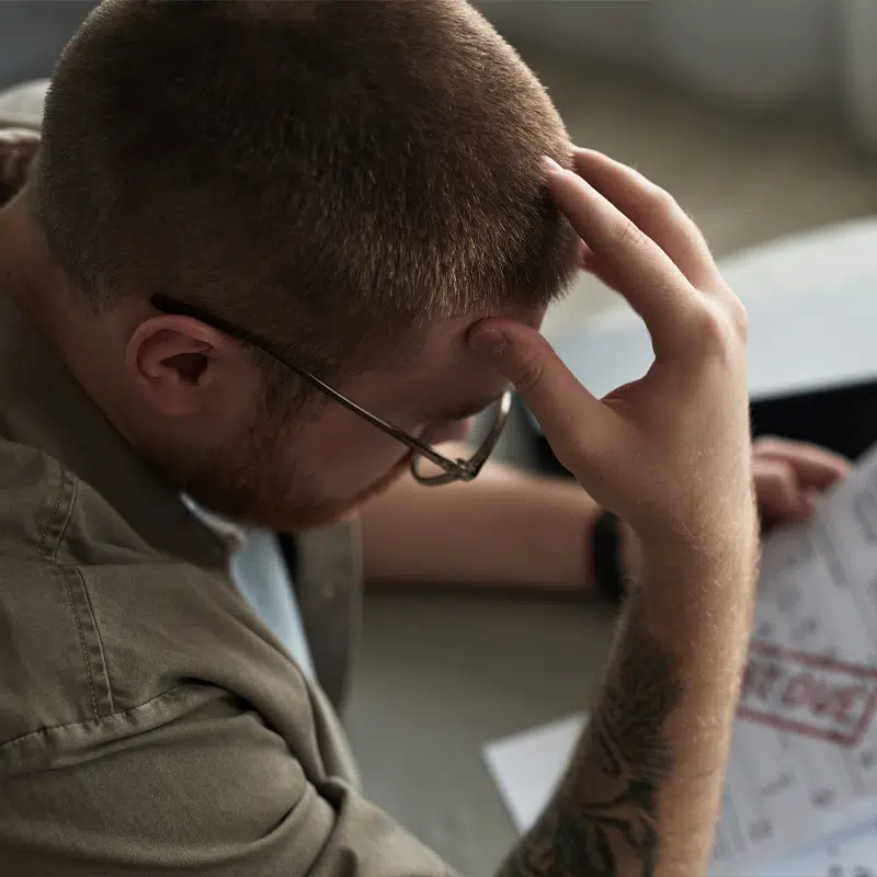 a man looks worried as he reads his bills